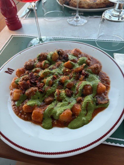 Une assiette de gnocchis à la sauce tomate et au pesto