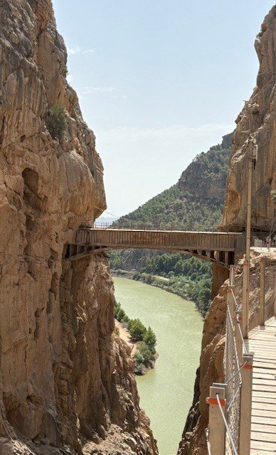 La passerelle et le pont suspendu du Caminito del Rey, au-dessus d'une rivière vert émeraude, entre deux parois rocheuses